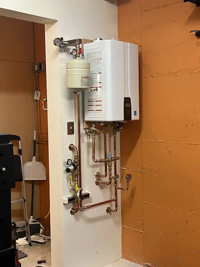Plumbing technician inspecting water heater connections in Mount Carmel